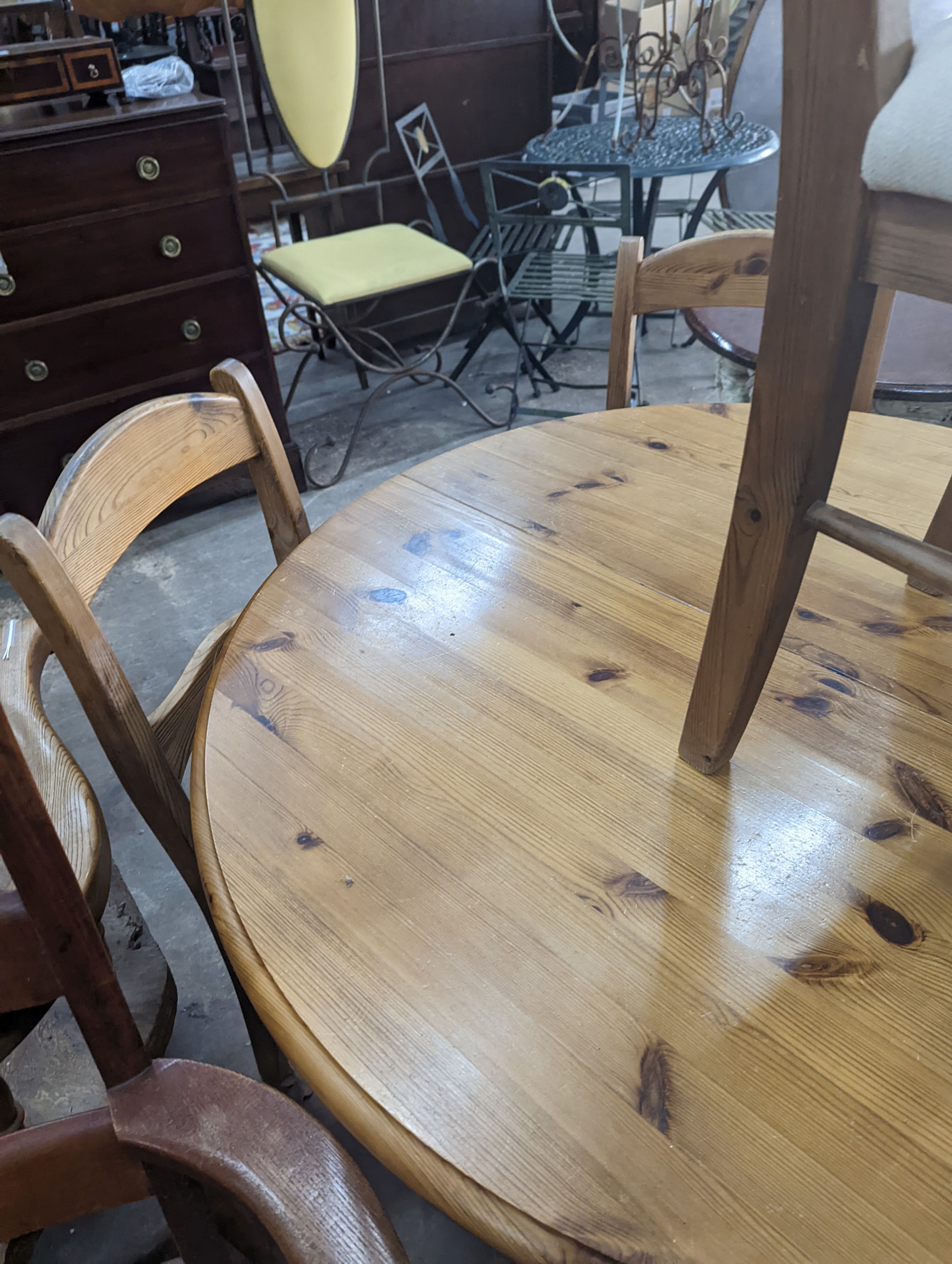 A reproduction circular pine breakfast table, diameter 105cm, height 77cm together with five pine dining chairs